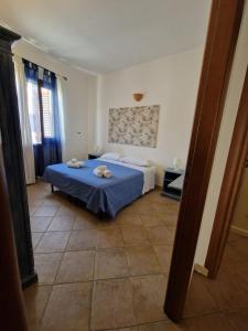Un dormitorio con una cama azul con toallas. en COLORI DEL MARE FAVIGNANA CENTRO en Favignana