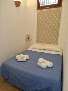 a blue bed with towels on top of it at COLORI DEL MARE FAVIGNANA CENTRO in Favignana
