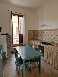 Il comprend une cuisine équipée d'une table, de chaises et d'une cuisinière. dans l'établissement COLORI DEL MARE FAVIGNANA CENTRO, à Favignana