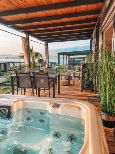 - un bain à remous sur une terrasse avec une table et des chaises dans l'établissement SEAYA mobile home - Terra Park SpiritoS, à Kolan