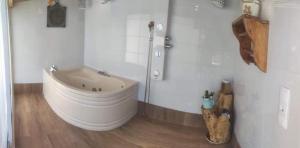 La salle de bains est pourvue d'une grande baignoire blanche. dans l'établissement Casa Pejão Do Paraíso, à Castelo de Paiva
