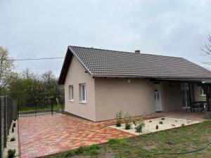 una pequeña casa con un patio de ladrillo frente a ella en Vivien vendégház 2, en Ordacsehi