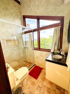 een badkamer met een douche, een toilet en een wastafel bij Taíba Beach Resort Surf House in Taíba