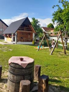 a playground with a log cabin in the background at Kuća za odmor Antonija in Gospić