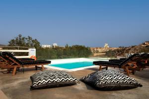 a patio with two pillows and a swimming pool at Sorocada Private House in Akrotiri