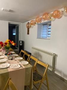 a dining room with a table with chairs and flowers at Casă de vacanţă ,,La Vălucu" in Curtea de Argeş