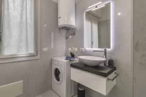 a bathroom with a sink and a washing machine at Vicolo Circolo @Castelvecchio in Verona