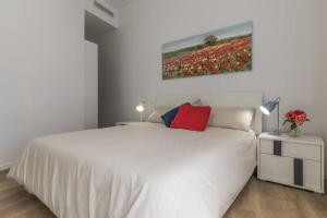 a bedroom with a white bed and a painting on the wall at Vicolo Circolo @Castelvecchio in Verona