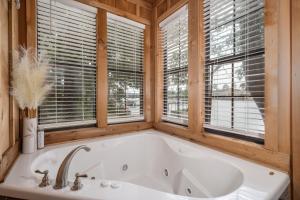 een bad in een houten badkamer met ramen bij Liams Lodge-Peaceful Cabin Panoramic Lake Views in Hot Springs