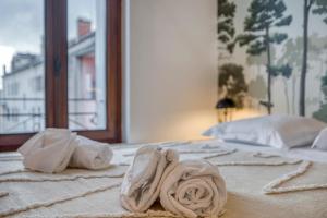 - un lit avec 2 serviettes dans l'établissement Le Carnot - MyCosyApart, Duplex Cœur de Ville et Lac, climatisé, à Annecy
