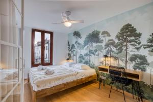 - une chambre avec un lit et une peinture murale dans l'établissement Le Carnot - MyCosyApart, Duplex Cœur de Ville et Lac, climatisé, à Annecy