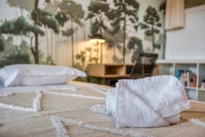 - un lit avec 2 serviettes dans l'établissement Le Carnot - MyCosyApart, Duplex Cœur de Ville et Lac, climatisé, à Annecy