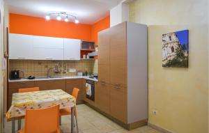 a kitchen with a table and a kitchen with orange walls at Vulcano in Pozzallo +5 photos