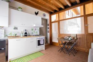 uma cozinha com electrodomésticos brancos e uma pequena mesa em Casa vacanze Monte Galetto em Bussolengo