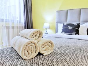 uma pilha de toalhas sentadas numa cama em Апартаменты MOON APARTMENTS - RIVER PARK em Almaty