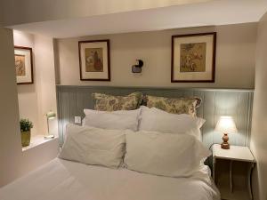 a bedroom with a bed with white sheets and pillows at Ground Floor - Hauseman Building close to Thermes in Luchon