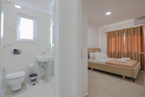 uma casa de banho com uma cama, um WC e um lavatório. em Relaxing Escape Rooms em Ksamil
