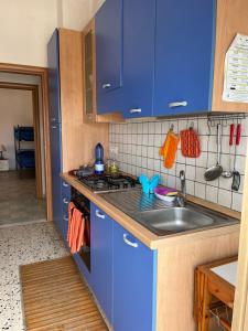 una cocina con armarios azules y fregadero en La Casa del Professore, en Nicotera Marina