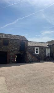 a brick building with a garage and a door at Highside Farm in Bassenthwaite