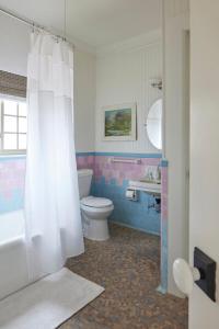 a bathroom with a white shower curtain and a toilet at The Villas at Spanish Court in Minden