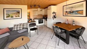 a living room and kitchen with a table and a couch at Ferienwohnung am Sonnenstrahl in Dorum-Neufeld