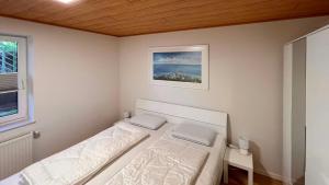 ein kleines Schlafzimmer mit einem Bett und einem Fenster in der Unterkunft Ferienwohnung am Sonnenstrahl in Dorum Neufeld
