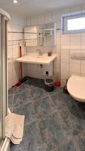 ein Bad mit einem Waschbecken und einem WC in der Unterkunft Ferienwohnung am Sonnenstrahl in Dorum Neufeld