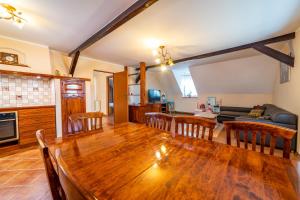 a kitchen and living room with a wooden table and chairs at Mia's House in Mikołajki