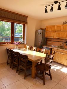 uma cozinha com uma grande mesa de madeira e cadeiras em Spacious family house in the city centre em Pāvilosta