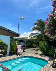 una piscina en un patio con sillas y flores en Cabinas Cahuita en Cahuita