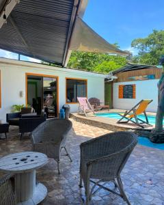 a patio with chairs and a table and a pool at Cabinas Cahuita in Cahuita