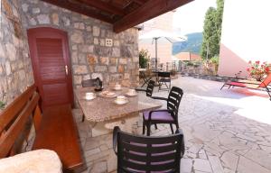 een patio met een tafel en stoelen in een stenen gebouw bij Guest House Roses in Ston
