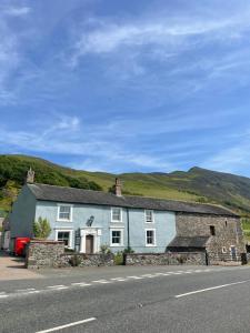 a blue and white house on the side of a road at Highside Farm in Bassenthwaite
