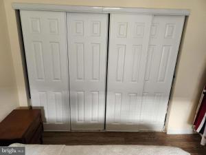 two white garage doors in a room with a bed at Quiet 2 Bedroom Apartment Condo in the Hampden / Medfield area few minutes to Downtown - Emerald Elite in Baltimore