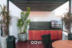 eine Küche mit einer Spüle, einem Tisch und Pflanzen in der Unterkunft Qavi - Flat completo no Bessa #GetOne314 in João Pessoa