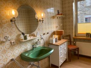 a bathroom with a green sink and a mirror at Stück vom Glück in Enkirch +19 photos