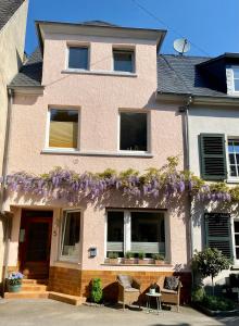 a pink house with purple flowers on it at Stück vom Glück in Enkirch