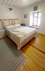 een slaapkamer met een groot wit bed en een raam bij Nil House Ayvalık in Ayvalık