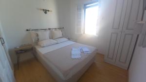een slaapkamer met een wit bed en 2 tafels erop bij Nil House Ayvalık in Ayvalık