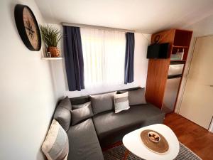sala de estar con sofá y reloj en la pared en Mobile home Nebo Luxus, en Klenovica