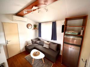una pequeña sala de estar con sofá y mesa. en Mobile home Nebo Luxus, en Klenovica
