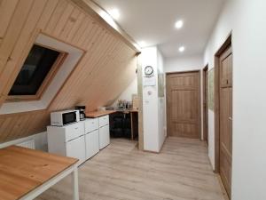 a kitchen with white cabinets and a wooden ceiling at Stara Kuźnia in Duszniki Zdrój