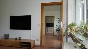 a living room with a flat screen tv on a wall at Große helle Ferienwohnung mit Balkon, ruhig gelegen mit guter Verkehrsanbindung in Bad Berneck im Fichtelgebirge