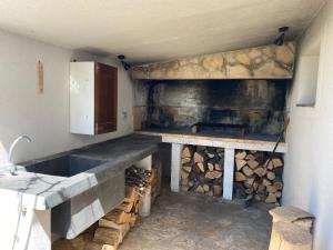 a kitchen with a pile of wood and a refrigerator at Apartman Palma in Vir
