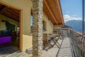 a patio with a table and chairs on a balcony at Chalet la terrazza vista lago in Bellano