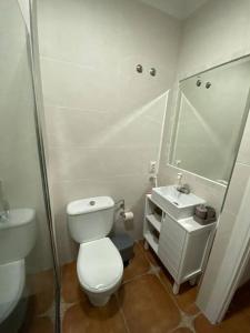 een witte badkamer met een toilet en een wastafel bij Casa Tagoror in Punta Umbría