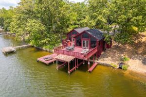 a red house on a dock in the water at Liam’s Lodge-Peaceful Cabin Panoramic Lake Views in Hot Springs