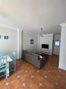 een woonkamer met een bank en een tafel bij Casa Tagoror in Punta Umbría