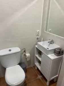 een badkamer met een wit toilet en een wastafel bij Casa Tagoror in Punta Umbría