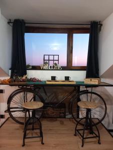 een tafel met twee krukken voor een raam bij CASETTA DEI RICCI in Vallecrosia